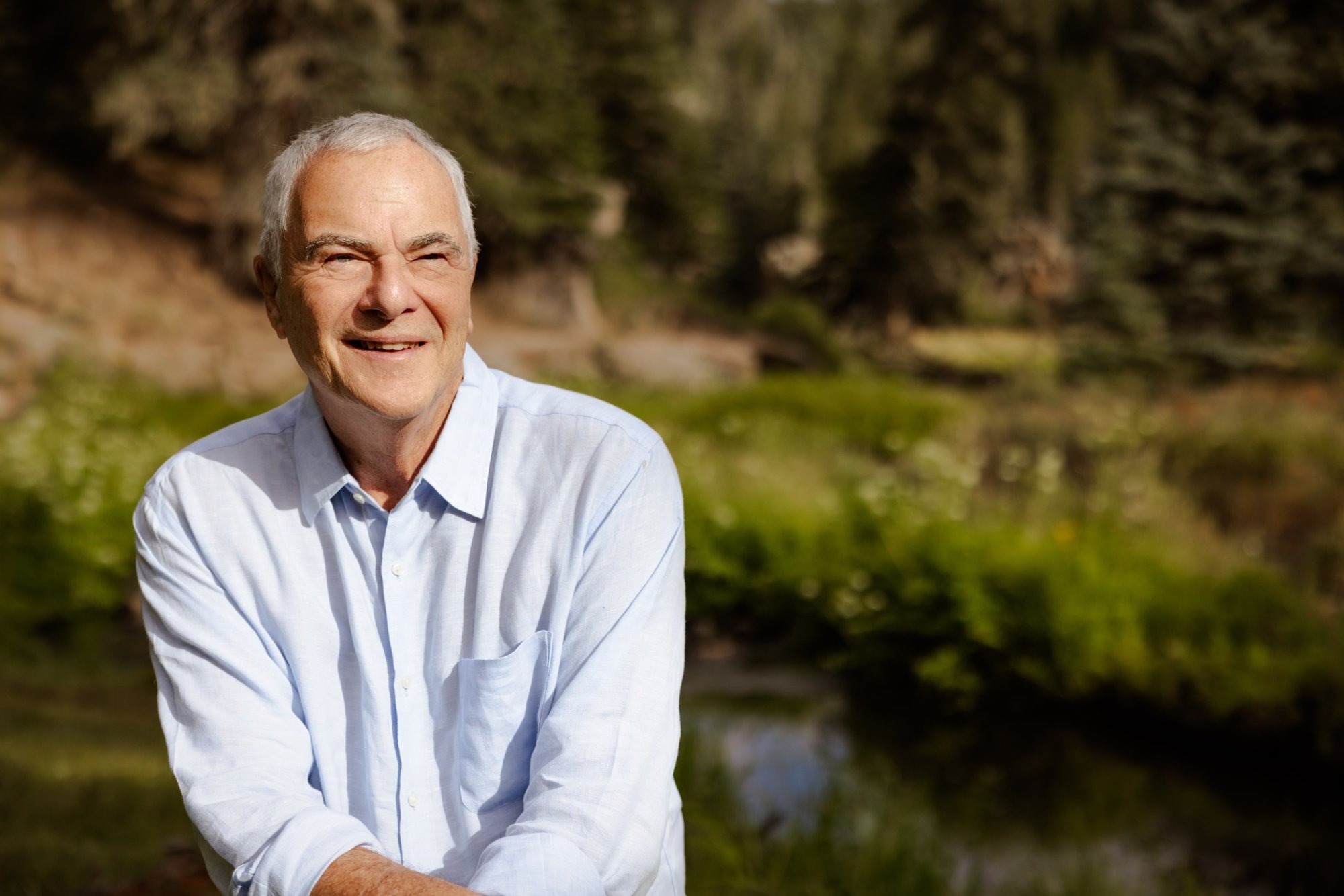 Brando Crespi smiling beside a mountain stream